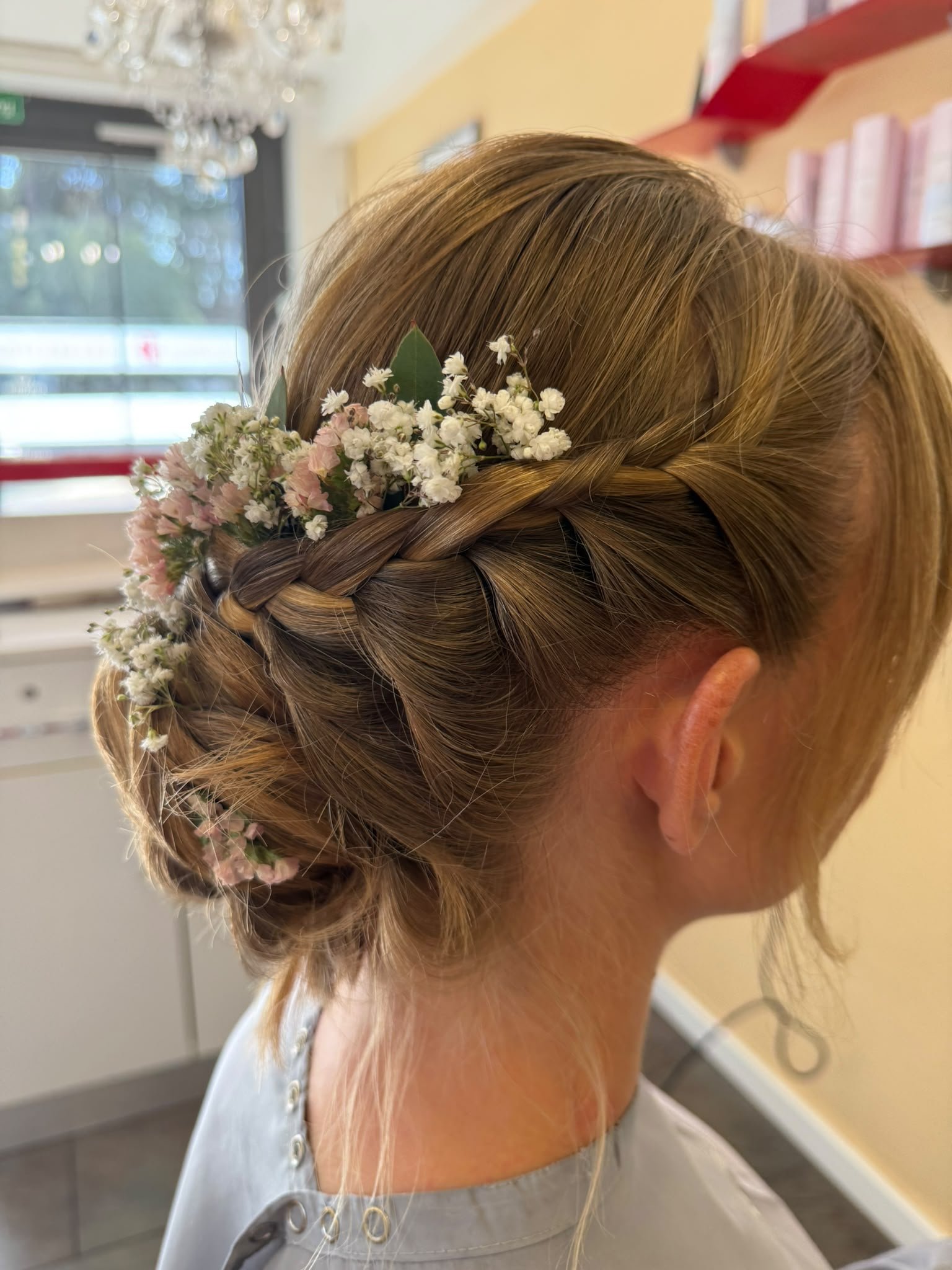 Seitlich geflochtene Hochsteckfrisur mit Blumenschmuck