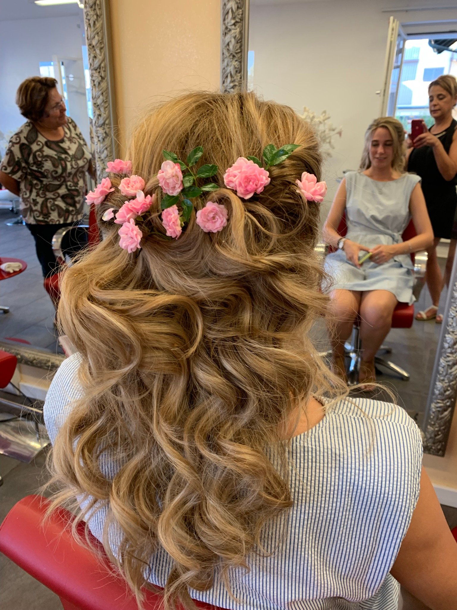 Halboffene Lockenfrisur mit rosa Rosen